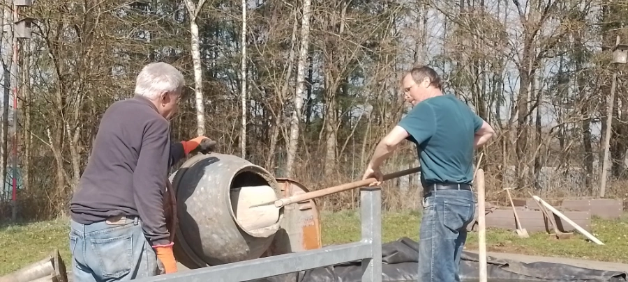 Zwei Mitglieder füllen einen Betonmischer im Lehrgarten des OGV Gilching