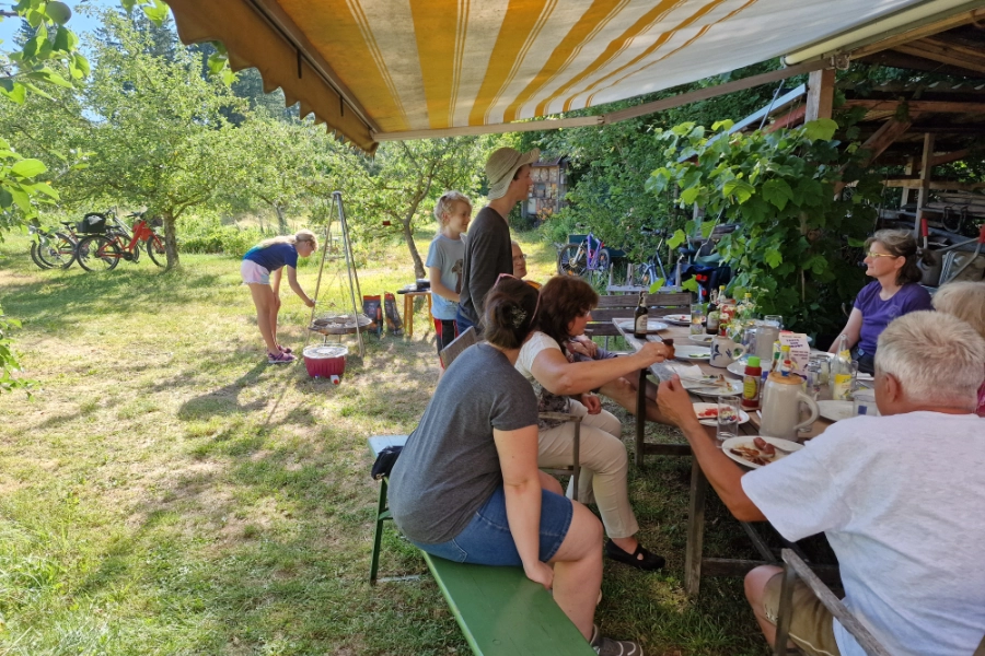 Personengruppe grillt bei einem Fest im Lehrgarten Gilching.